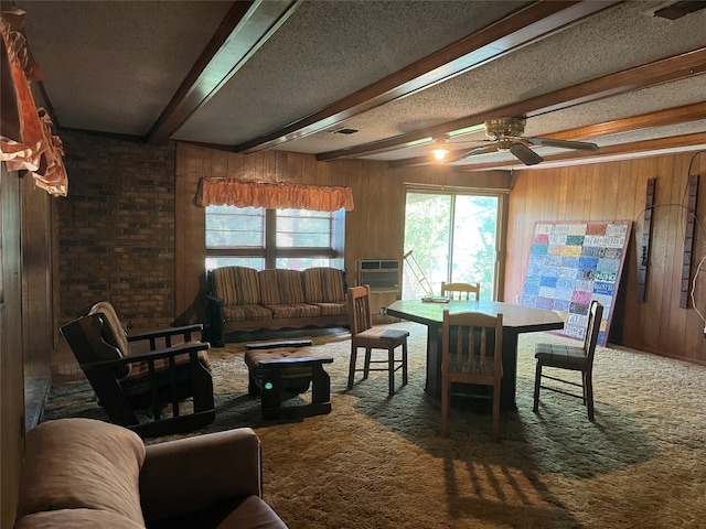 dining area with dark carpet, beamed ceiling, and wooden walls