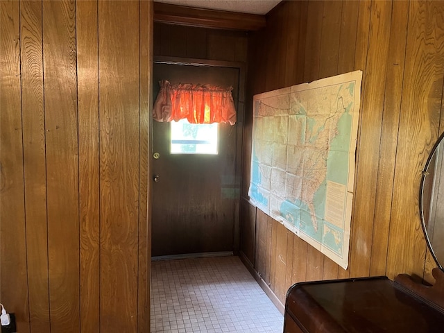 doorway to outside featuring wood walls and tile flooring