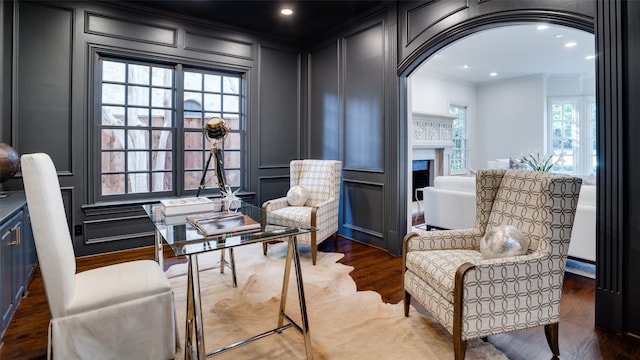 living area with crown molding and dark hardwood / wood-style flooring