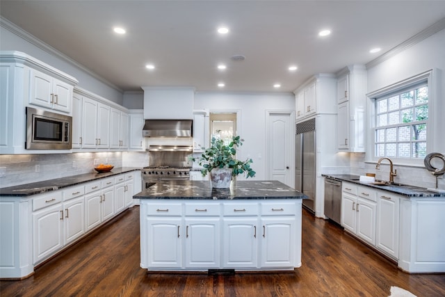 kitchen featuring white cabinetry, tasteful backsplash, built in appliances, and a kitchen island