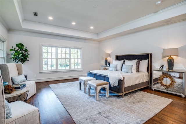 bedroom with a raised ceiling, ornamental molding, and dark wood-type flooring