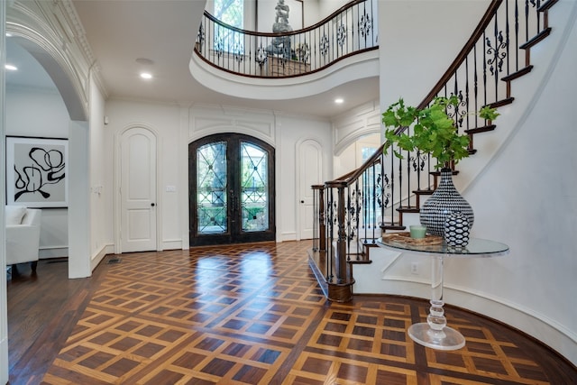 entryway featuring crown molding, french doors, a wealth of natural light, and dark hardwood / wood-style floors