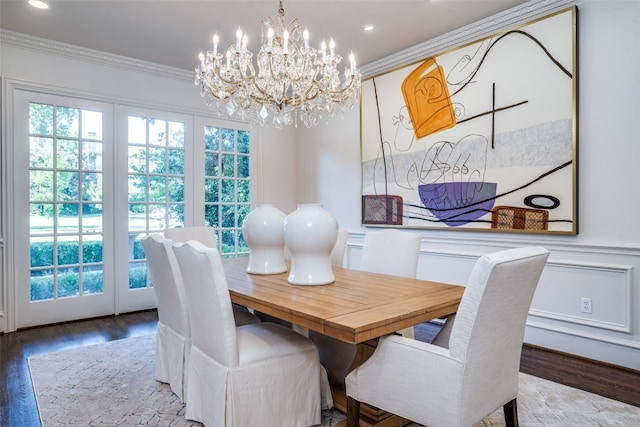 dining space with ornamental molding, hardwood / wood-style floors, and a notable chandelier