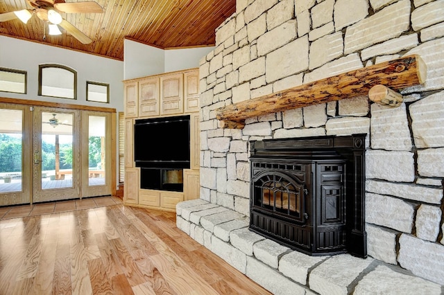 unfurnished living room with light hardwood / wood-style floors, high vaulted ceiling, a fireplace, ceiling fan, and wood ceiling