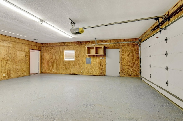 garage with wooden walls and a garage door opener