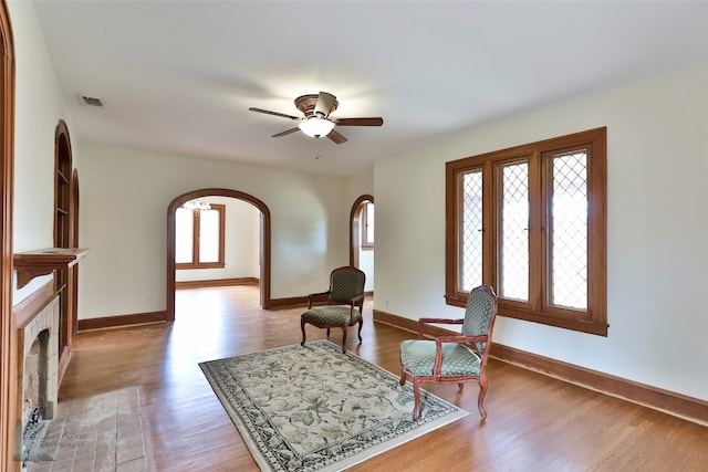 entryway with a brick fireplace, ceiling fan, and hardwood / wood-style flooring