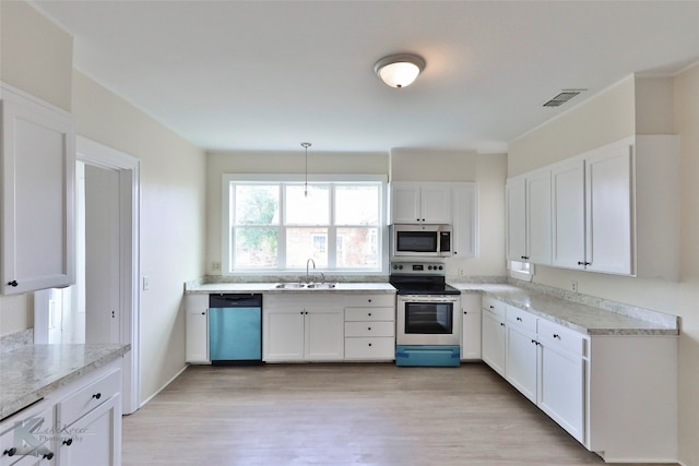 kitchen with light hardwood / wood-style floors, white cabinets, appliances with stainless steel finishes, and sink