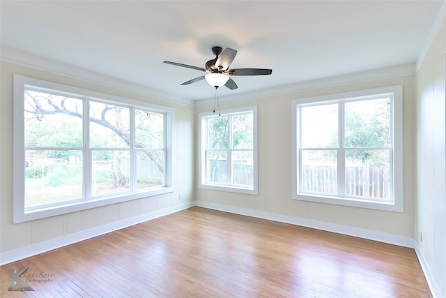 empty room featuring ceiling fan, ornamental molding, light hardwood / wood-style floors, and plenty of natural light