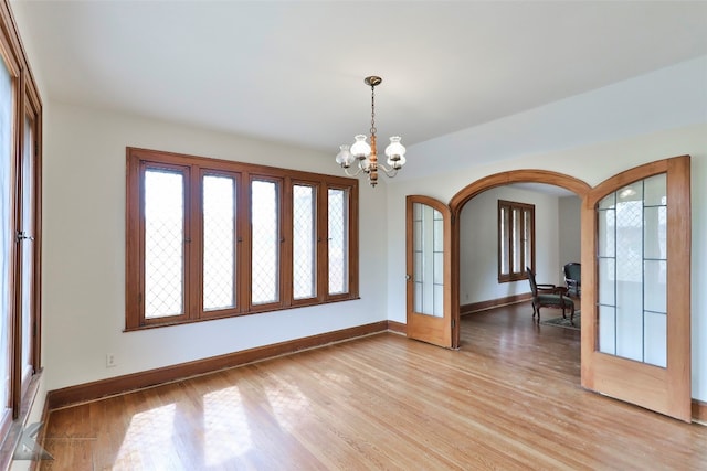 empty room featuring light hardwood / wood-style flooring and an inviting chandelier