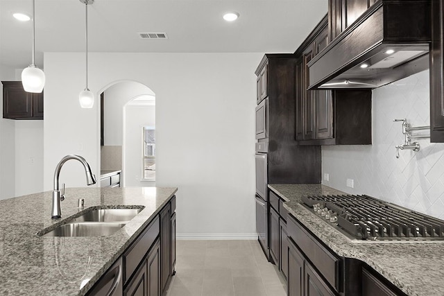 kitchen with premium range hood, hanging light fixtures, stainless steel appliances, light tile flooring, and sink