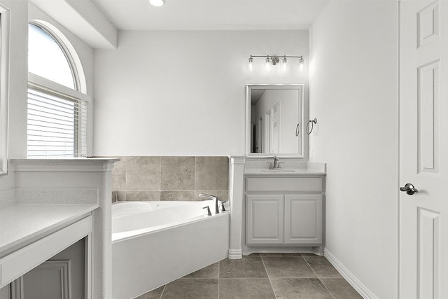 bathroom with a bathing tub, vanity, and tile floors