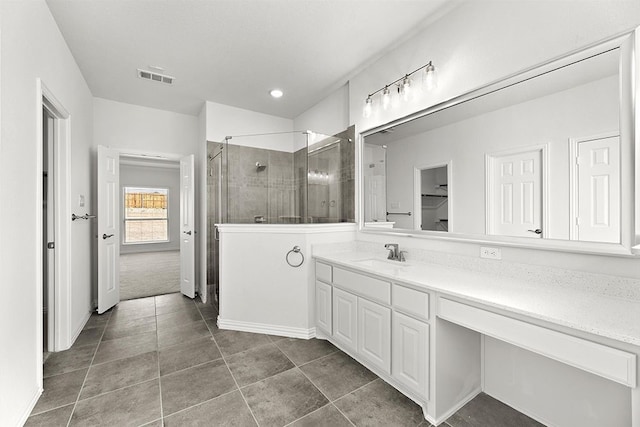 bathroom with tile flooring, vanity, and an enclosed shower