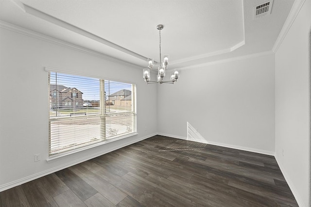 spare room featuring ornamental molding, dark wood-type flooring, a raised ceiling, and an inviting chandelier