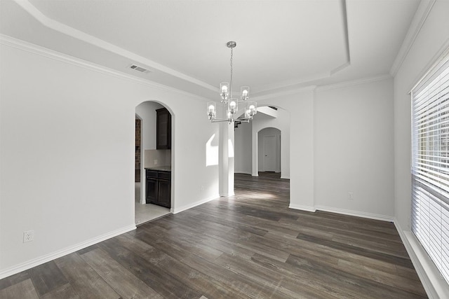 spare room featuring dark hardwood / wood-style floors, a tray ceiling, and an inviting chandelier