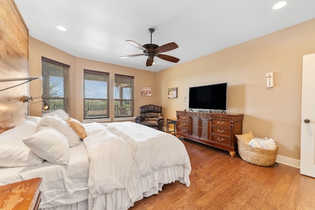 bedroom with dark hardwood / wood-style flooring and ceiling fan