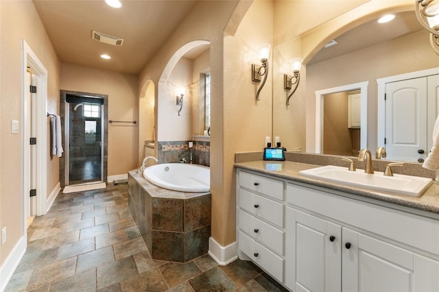 bathroom featuring vanity, tile floors, and tiled bath