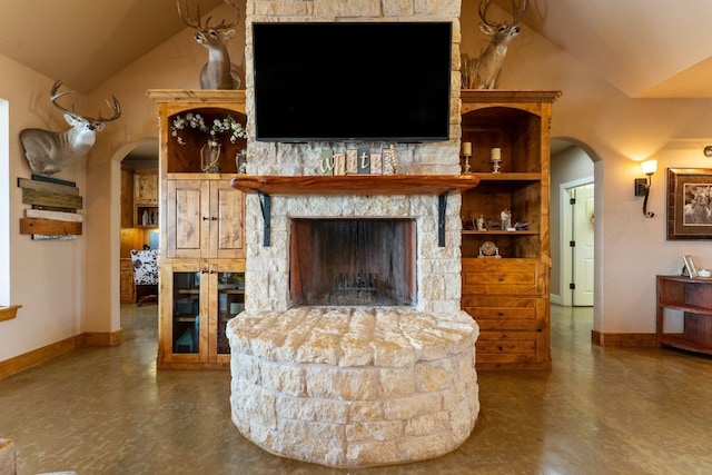 living room with lofted ceiling and a stone fireplace