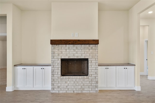 unfurnished living room with a fireplace and light hardwood / wood-style floors