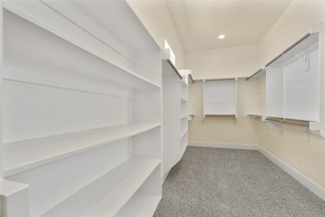 walk in closet featuring light colored carpet