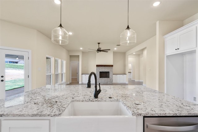 kitchen with ceiling fan, sink, white cabinetry, and hanging light fixtures