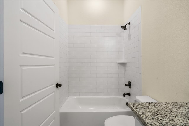 bathroom featuring tiled shower / bath combo and toilet