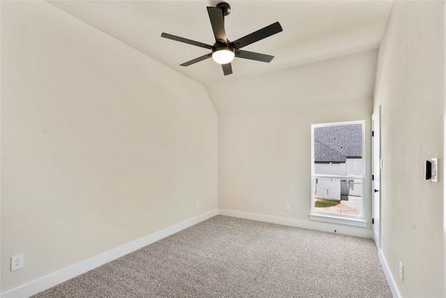 carpeted empty room with vaulted ceiling and ceiling fan