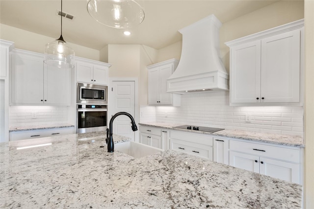 kitchen with sink, stainless steel appliances, pendant lighting, white cabinets, and custom range hood