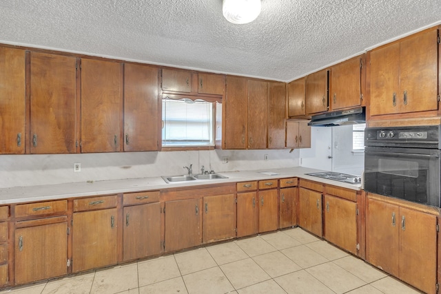 kitchen featuring light tile patterned floors, sink, a textured ceiling, white gas cooktop, and black oven