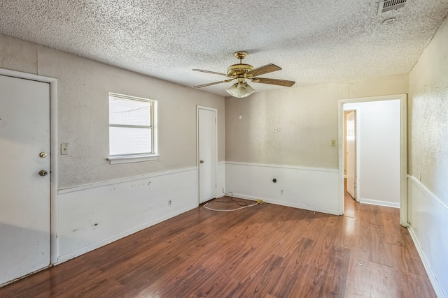 unfurnished room with ceiling fan, hardwood / wood-style flooring, and a textured ceiling