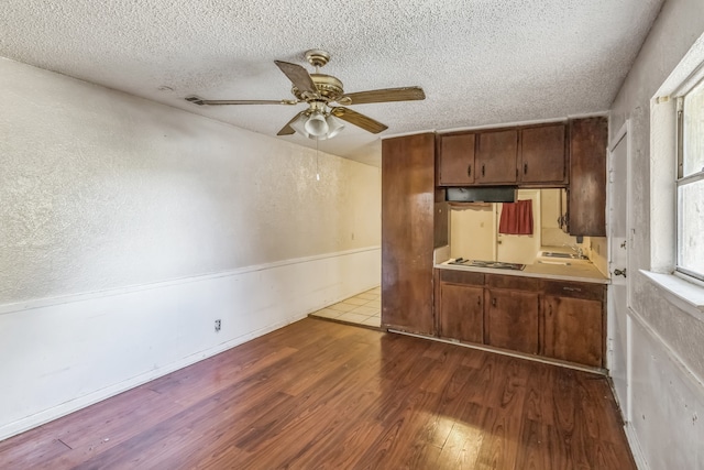 kitchen with ceiling fan, wood-type flooring, sink, white gas cooktop, and a textured ceiling