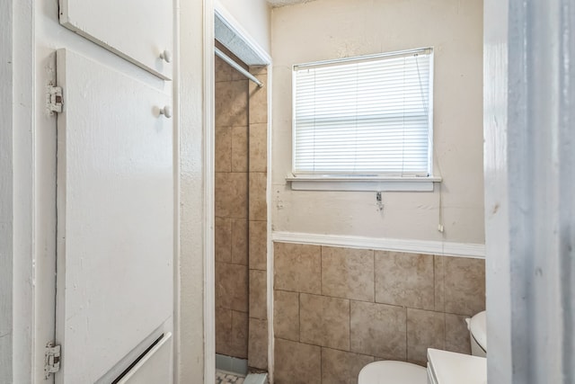 bathroom with toilet and a shower with door