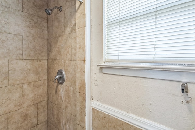 interior details featuring a tile shower