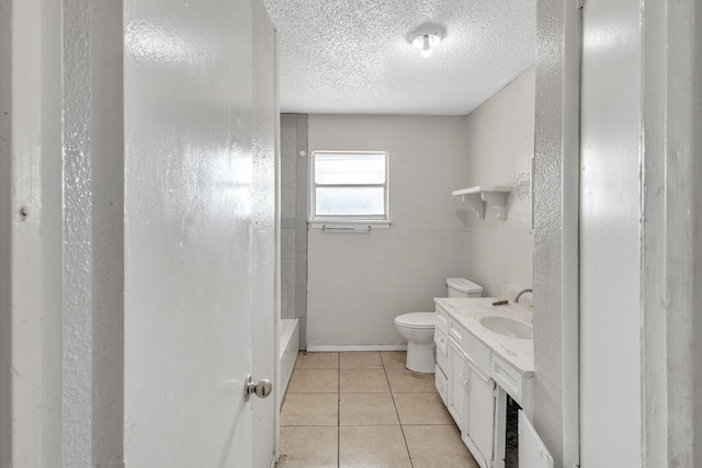 bathroom featuring vanity, a textured ceiling, a shower, tile patterned floors, and toilet