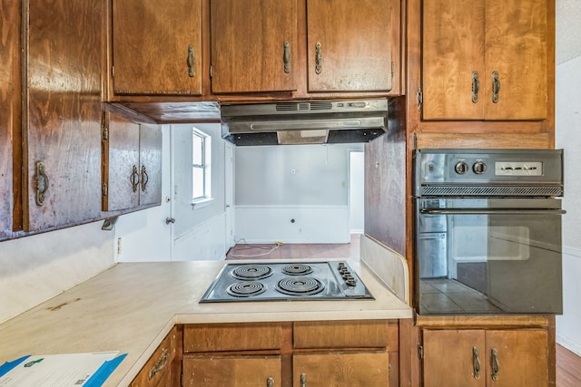 kitchen featuring hardwood / wood-style flooring, extractor fan, and black appliances