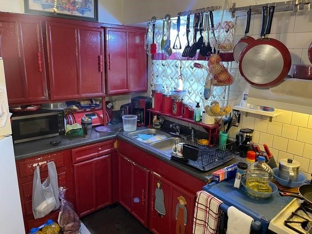 kitchen featuring white refrigerator and tasteful backsplash