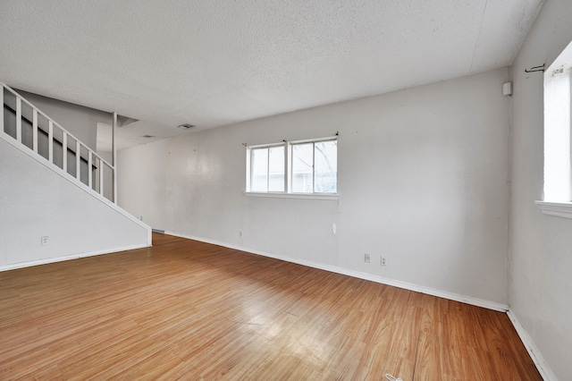 spare room featuring wood-type flooring and a textured ceiling