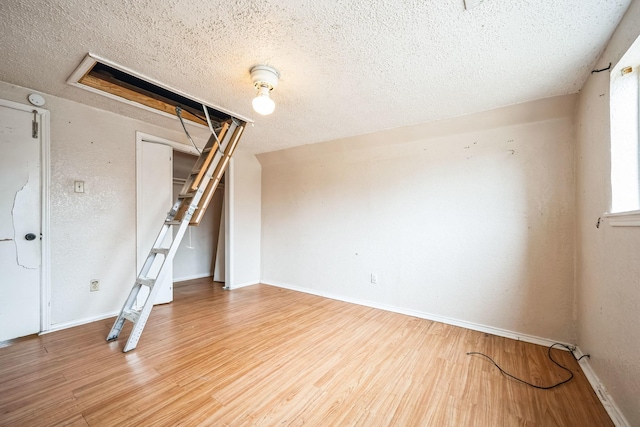 unfurnished room with hardwood / wood-style floors and a textured ceiling