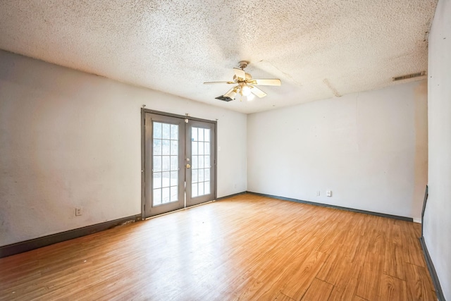 spare room with ceiling fan, french doors, a textured ceiling, and light wood-type flooring