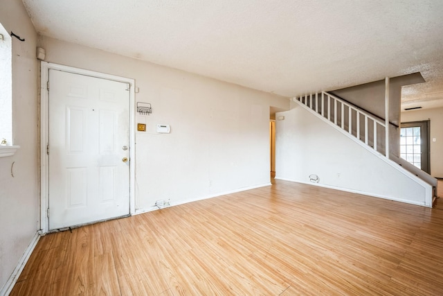 interior space featuring wood-type flooring and a textured ceiling