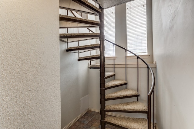 stairway featuring dark tile floors