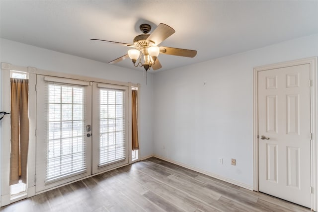 spare room with ceiling fan, light hardwood / wood-style flooring, and french doors