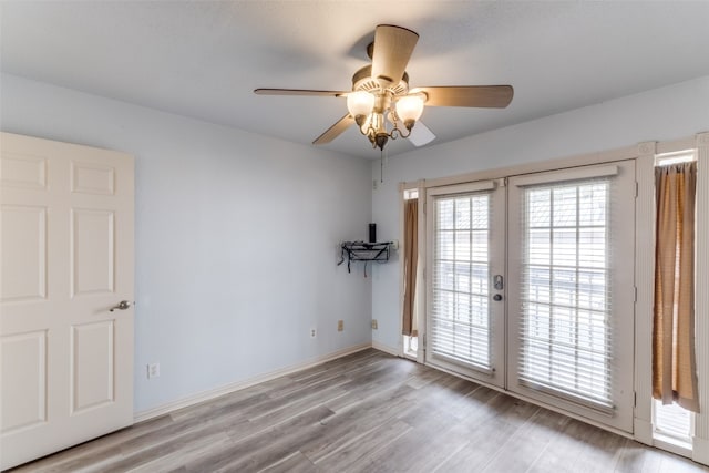 unfurnished room with ceiling fan, light hardwood / wood-style floors, and french doors