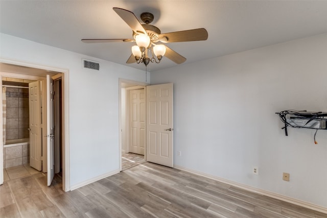 unfurnished bedroom featuring connected bathroom, ceiling fan, and light wood-type flooring