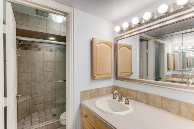 bathroom with toilet, a textured ceiling, vanity, and a shower with door