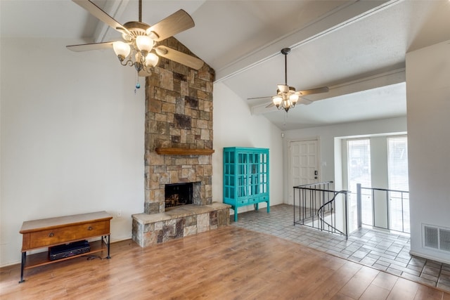 living room with a fireplace, ceiling fan, light wood-type flooring, and lofted ceiling with beams