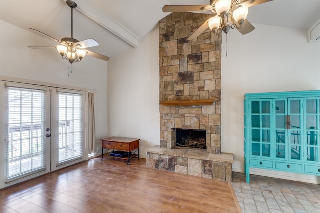 unfurnished living room with ceiling fan, beam ceiling, a stone fireplace, and dark wood-type flooring