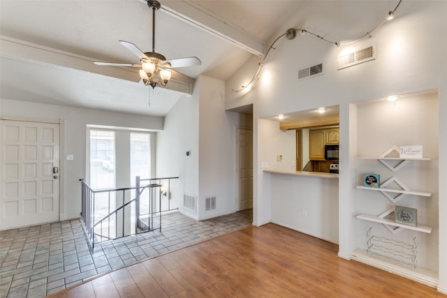 unfurnished living room with ceiling fan, vaulted ceiling with beams, and light hardwood / wood-style flooring