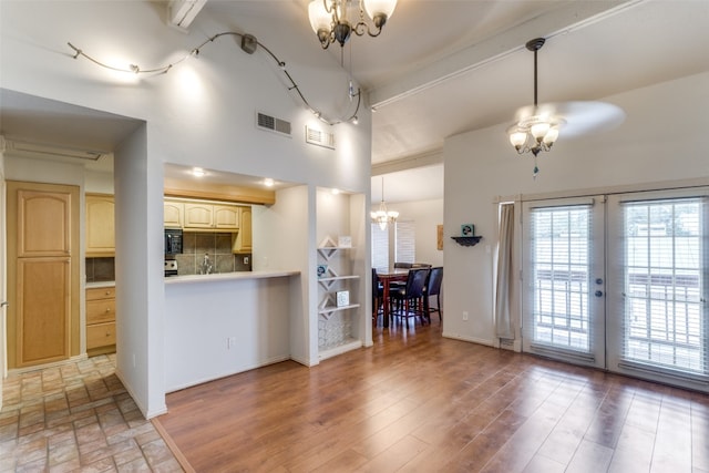 kitchen with pendant lighting, french doors, beamed ceiling, tasteful backsplash, and wood-type flooring