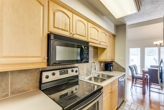 kitchen with sink, stainless steel appliances, light tile floors, a chandelier, and tasteful backsplash