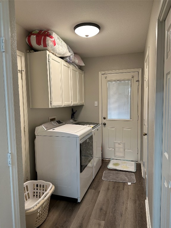 clothes washing area featuring independent washer and dryer, cabinets, dark wood-type flooring, and washer hookup